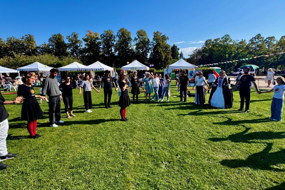 Gemeinsamer Tanz mit der Folkloregruppe Syrtos_Foto Kseniya Ibadulima Das Foto zeigt eine Gruppe von Menschen, die gemeinsam tanzen