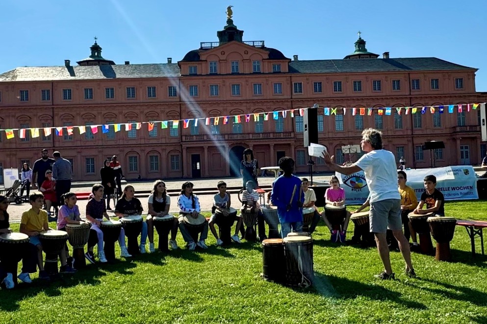 Perkussionist Notker Dreher mit der Trommelgruppe K.i.d.S., Klasse 4b der Karlschule_Foto Kseniya Ibadulima Das Foto zeigt eine Gruppe von Menschen, die gemeinsam musizieren